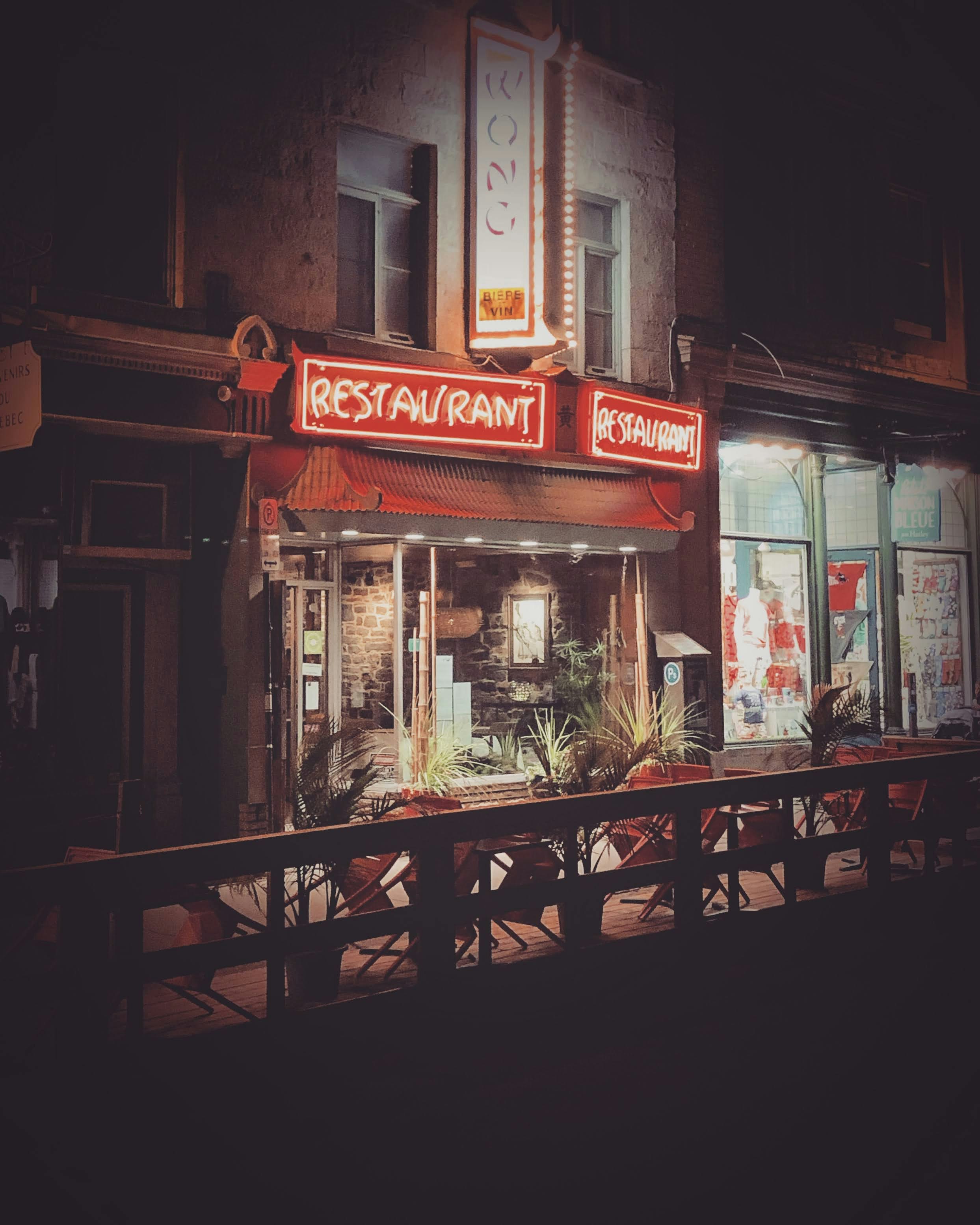 brown wooden chairs and tables in front of store during night time